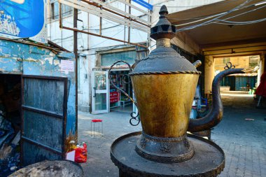 Urumçi, Xinjiang, Çin 'deki geleneksel bir pazarda büyük bir çöp yığını ve büyük boy Uygur çaydanlığı simgesi.