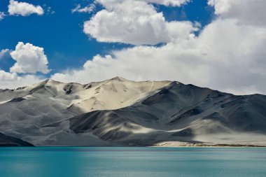 Baisha Dağı ve zümrüt göl suyuyla birlikte Xinjiang Pamir Platosu 'ndaki Baisha Gölü.