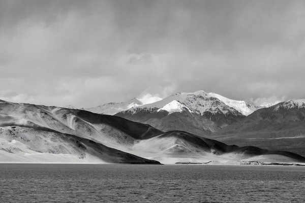 Baisha Dağı ve zümrüt göl suyuyla birlikte Xinjiang Pamir Platosu 'ndaki Baisha Gölü.