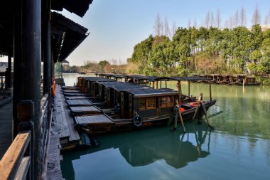 Küçük nehir, ahşap kayıklar, taş köprüler ve güney Çin 'deki küçük bir su kasabasında taş tuğlalarla döşenmiş eski sokak ahşap dükkanları.