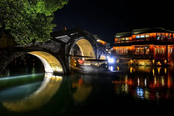 中国南部の小さな水の町に石レンガで舗装された小さな川 木製のボート 石の橋や古い通りの木製のお店 — ストック写真