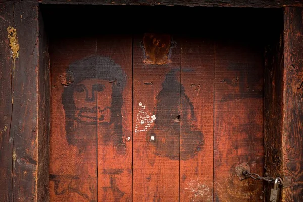There are simple blessing graffiti on the red wooden door of the stone house of the alpine herdsmen in the Tibetan area of China
