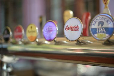 Bir bar tezgahında farklı marka bira tutacakları.