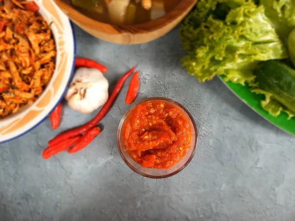 Kırmızı biberli, sarımsaklı ve taze sebzeli cam bir kasede domates sosu (sambal).