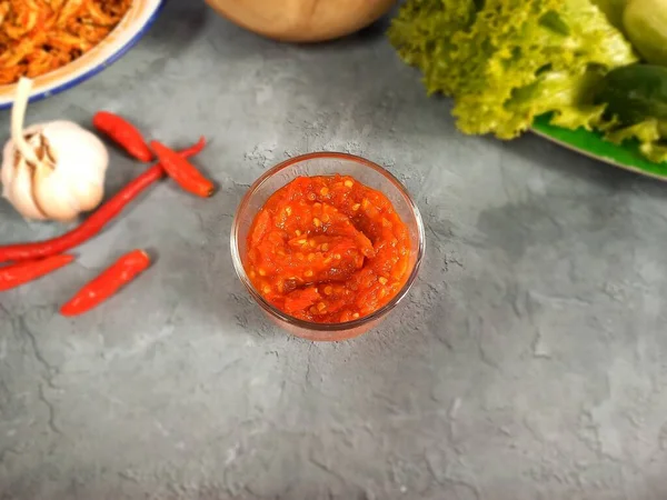 Kırmızı biberli, sarımsaklı ve taze sebzeli cam bir kasede domates sosu (sambal).