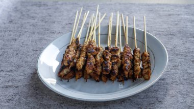 Evde yiyecek ve içecekle çevrili yeni yapılmış bir satay tabağının kuş bakışı görüntüsü. Tazeliği aşikar. manzara