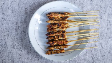 Evde yiyecek ve içecekle çevrili yeni yapılmış bir satay tabağının kuş bakışı görüntüsü. Tazeliği aşikar. en üstteki görünüm