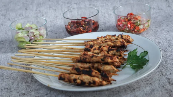 Turşu, soya sosu ve taze ve sağlıklı malzemelerden yapılmış sambal matah ile yakın çekim satay tabağı. Besleyici bir yemek için mükemmel.. 