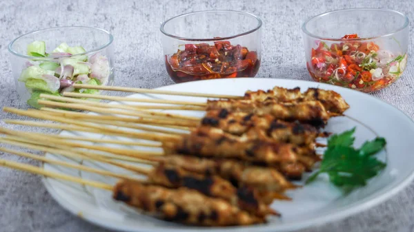 Turşu, soya sosu ve taze ve sağlıklı malzemelerden yapılmış sambal matah ile yakın çekim satay tabağı. Besleyici bir yemek için mükemmel.. 