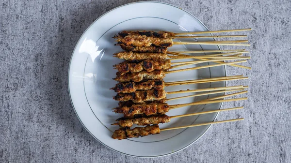 Evde yiyecek ve içecekle çevrili yeni yapılmış bir satay tabağının kuş bakışı görüntüsü. Tazeliği aşikar. en üstteki görünüm