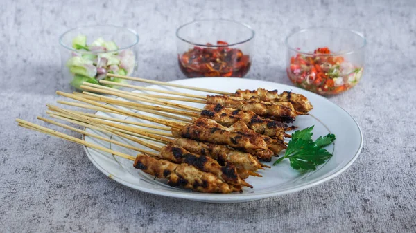 Turşu, soya sosu ve taze ve sağlıklı malzemelerden yapılmış sambal matah ile yakın çekim satay tabağı. Besleyici bir yemek için mükemmel.. 