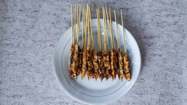 Evde yiyecek ve içecekle çevrili yeni yapılmış bir satay tabağının kuş bakışı görüntüsü. Tazeliği aşikar. en üstteki görünüm