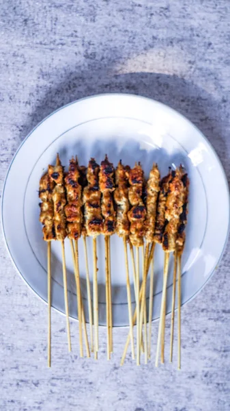 Bir stüdyo ortamında taze yapılmış arrosticini satay yakın çekim, yemeğin tazeliğini ve lezzetini iletiyor..