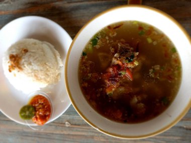 Sop iga ya da pirzola çorbası bir tabak pirinçli ve havuçlu. Protein, vitamin ve lif gibi beyaz bir kasede et ve sebze çorbası.