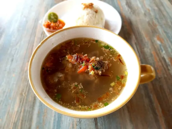 Sop iga ya da pirzola çorbası bir tabak pirinçli ve havuçlu. Protein, vitamin ve lif gibi beyaz bir kasede et ve sebze çorbası.