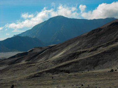 Gün boyunca Bromo Dağı volkanik kumu. Bulutlu dağ manzarası