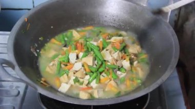 Tofu ve sebze kızartması tavada pişer. Yerel Endonezya yemekleri