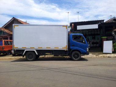 Otoparkta karavanı olan küçük kamyonlar.