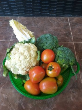 Taze domates, brokoli, karnabahar ve temiz yemek için yapraklı lahana sepeti içinde çevre dostu sebze seçimi.