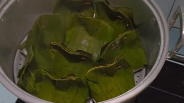 Muz yapraklarına sarılmış Güneydoğu Asya geleneksel lezzetlerine yakın çekim. Muz yapraklı körili balık.