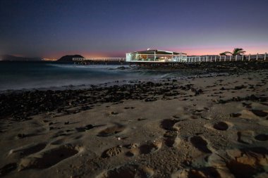 Kumsalda güzel bir sabah. Denizde uzun süre kalmışlar. Sis ve sisin içinde sütlü gün doğumu. Corralejo, Kanarya Adaları, İspanya