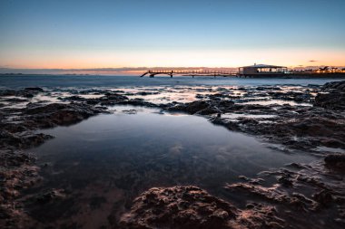 Kumsalda güzel bir sabah. Denizde uzun süre kalmışlar. Sis ve sisin içinde sütlü gün doğumu. Corralejo, Kanarya Adaları, İspanya