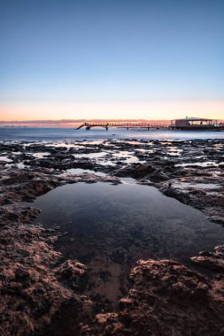 Kumsalda güzel bir sabah. Denizde uzun süre kalmışlar. Sis ve sisin içinde sütlü gün doğumu. Corralejo, Kanarya Adaları, İspanya