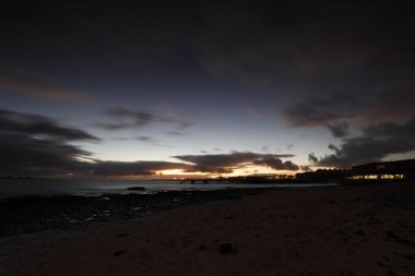 Kumsalda güzel bir sabah. Denizde uzun süre kalmışlar. Sis ve sisin içinde sütlü gün doğumu. Corralejo, Kanarya Adaları, İspanya