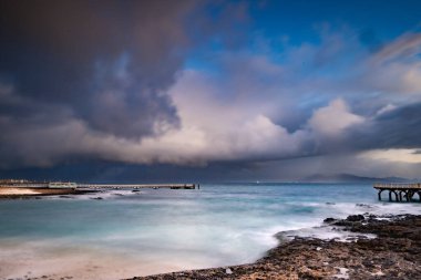 Kumsalda güzel bir sabah. Denizde uzun süre kalmışlar. Sis ve sisin içinde sütlü gün doğumu. Corralejo, Kanarya Adaları, İspanya