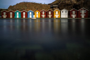 İsveç evleri, İsveç sisinde küçük renkli balıkçıların evleri. Arka planda kaya olan deniz kıyısında harika bir şehir.
