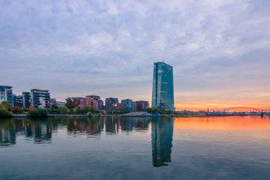 Frankfurt 'ta gün batımı. Skyline çelik köprünün altına sıkışmış. Nehrin kıyısında ve Frankfurt 'taki ECB' de.