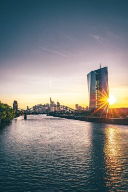 Frankfurt 'ta ufuk çizgisi. Main nehrinin kıyısındaki büyük bir şehirde eşsiz bir ışık. Sudaki yansıma. Sokak fotoğrafçılığı, su birikintileri, manzaralar, geçitler ve mimari