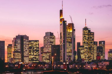 Gün batımında Frankfurt manzarası. Ufuk çizgisi manzaralı arka plan çekimi. Finans bölgesindeki banka ve sigorta şirketlerinin yüksek binaları