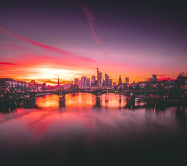 Bir izleme platformundan Skyline görüntüsü. Almanya 'da Frankfurt am Main' de akşamları gökyüzünün ortasında rüya gibi bir günbatımı görülür. Finans bölgesinin büyük şehir fotoğrafı.