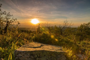 Doğanın ortasında gün batımının güzel manzarası. Bir dağdan alındığında, vahşi doğaya romantik bir bakış açın var. Akşamları gökyüzü özellikle renklidir.