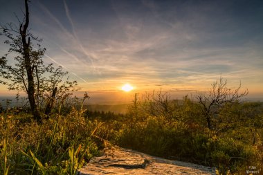 Doğanın ortasında gün batımının güzel manzarası. Bir dağdan alındığında, vahşi doğaya romantik bir bakış açın var. Akşamları gökyüzü özellikle renklidir.