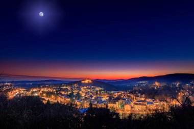 Frankfurt yakınlarında Knigstein im Taunus. Gün batımından sonra kalenin manzarası harabeye döner. Kışın aydınlatılmış kale ve köy