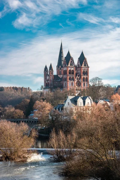 Limburg Almanya 'sındaki katedral. Güneşin doğuşunda heykeli ve nehri olan eski bir köprünün üzerinde güzel bir manzara.