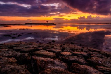 Sanur 'da Bali' de gün batımı ya da gün doğumu. Sakin sularda, harika renklerde güzel tapınaklar.