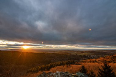 Groer Zacken 'deki manzara, Taunus volkanik bölgesi. Bulutlu, güneşli bir sonbahar günü, gün batımını gören çayırlar, tepeler, tarlalar ve ormanlar. Hesse, Almanya