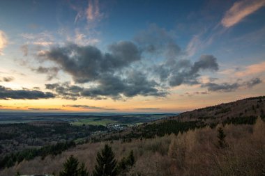 Groer Zacken 'deki manzara, Taunus volkanik bölgesi. Bulutlu, güneşli bir sonbahar günü, gün batımını gören çayırlar, tepeler, tarlalar ve ormanlar. Hesse, Almanya