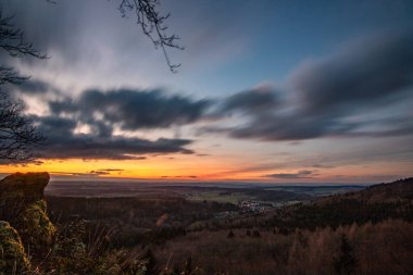 Groer Zacken 'deki manzara, Taunus volkanik bölgesi. Bulutlu, güneşli bir sonbahar günü, gün batımını gören çayırlar, tepeler, tarlalar ve ormanlar. Hesse, Almanya