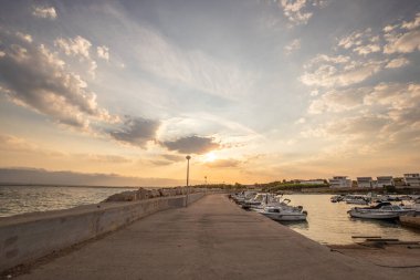 Sabahları küçük limanı olan bir sahil. Akdeniz 'de güzel bir gün doğumu. Vir, Zadar, Dalmaçya, Adriyatik Denizi, Hırvatistan 'ın Akdeniz kıyıları ve manzarası