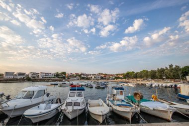 Sabahları küçük limanı olan bir sahil. Akdeniz 'de güzel bir gün doğumu. Vir, Zadar, Dalmaçya, Adriyatik Denizi, Hırvatistan 'ın Akdeniz kıyıları ve manzarası