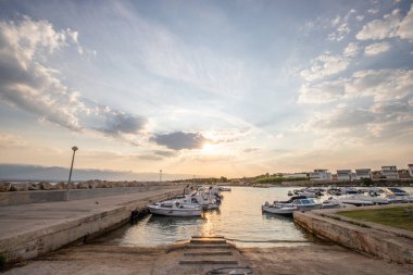Sabahları küçük limanı olan bir sahil. Akdeniz 'de güzel bir gün doğumu. Vir, Zadar, Dalmaçya, Adriyatik Denizi, Hırvatistan 'ın Akdeniz kıyıları ve manzarası