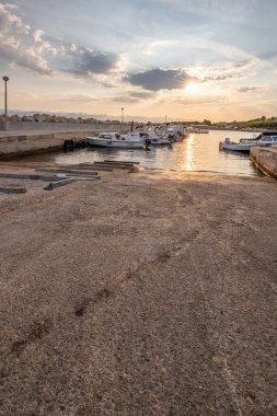 Sabahları küçük limanı olan bir sahil. Akdeniz 'de güzel bir gün doğumu. Vir, Zadar, Dalmaçya, Adriyatik Denizi, Hırvatistan 'ın Akdeniz kıyıları ve manzarası