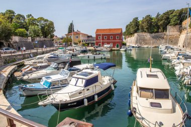 Zadarske gradske zidine, küçük tekneleri ve kendine özgü kırmızı bir evi olan tarihi liman. Adriyatik Denizi, Dalmaçya ve Hırvatistan 'ın eski Zadar kentinin etkileyici şehir duvarlarının önünde
