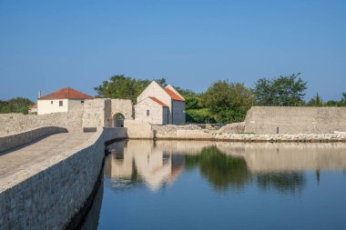 Küçük bir Akdeniz kasabasının Skyline 'ı, tarihi şehir merkezi. Körfez veya lagün adalarında devasa şehir duvarları var. Nin, Zadar, Dalmaçya, Hırvatistan ve Adriyatik 'te sabah havası