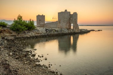 Şafak vakti kale harabeye döner. Akdeniz 'de güneş doğarken sakin sularla dolu bir körfez. Kastelina Kalesi, Vir Adası, Zadar, Dalmaçya, Hırvatistan, Adriyatik Denizi 'nin Gökyüzü ve Akdeniz manzarasının yansıması