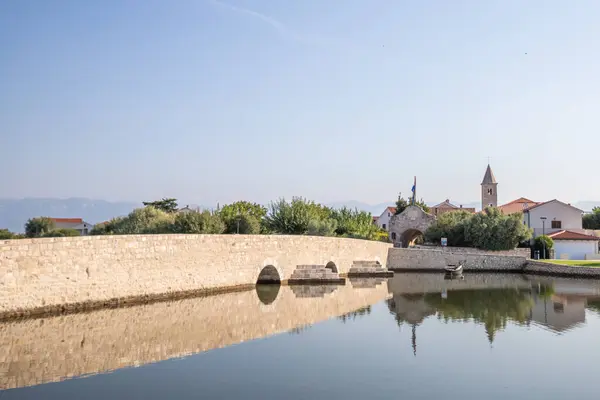Küçük bir Akdeniz kasabasının Skyline 'ı, tarihi şehir merkezi. Körfez veya lagün adalarında devasa şehir duvarları var. Nin, Zadar, Dalmaçya, Hırvatistan ve Adriyatik 'te sabah havası